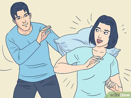 Step 5 Toss a pillow at her lightly to start a pillow fight.